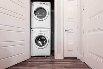 a white washer and dryer in a white closet